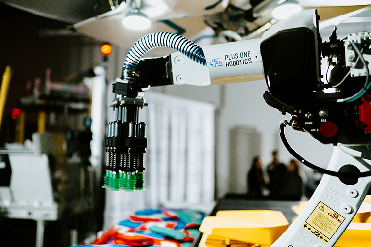 Foto eines Roboterarms über einem Förderband