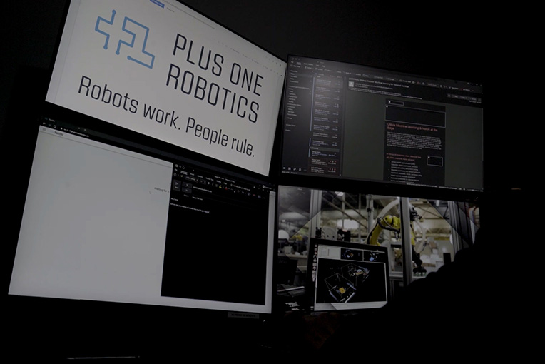Ein Mann überwacht die Arbeit von Robotern in einem Büro an einem Arbeitsplatz mit vier Monitoren