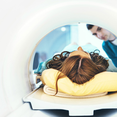 A person in an MRI machine in a medical setting showing a high tech application of an medical computer